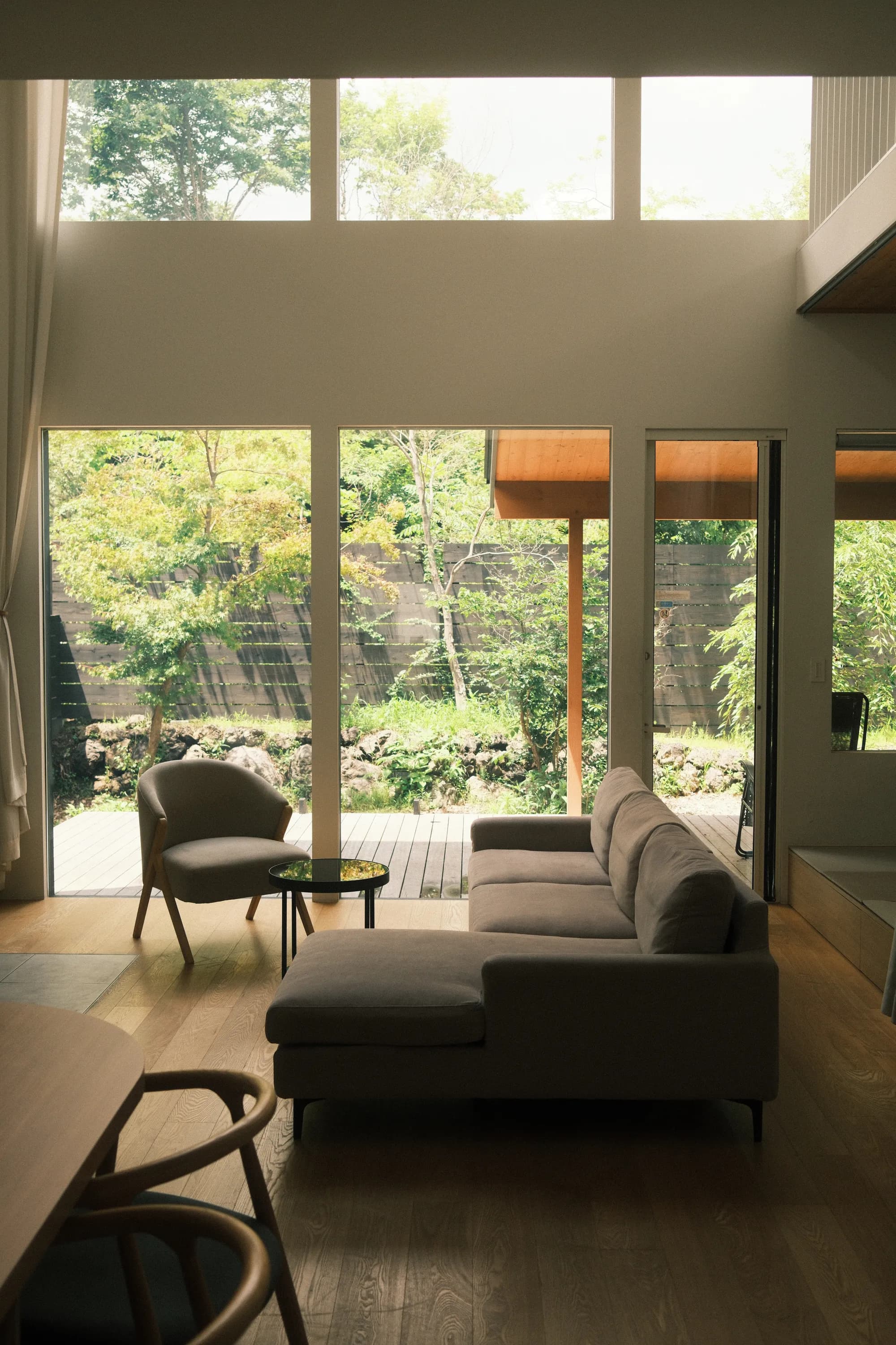 The living room of a villa operated by Asagiri Inc., opening onto woodland.